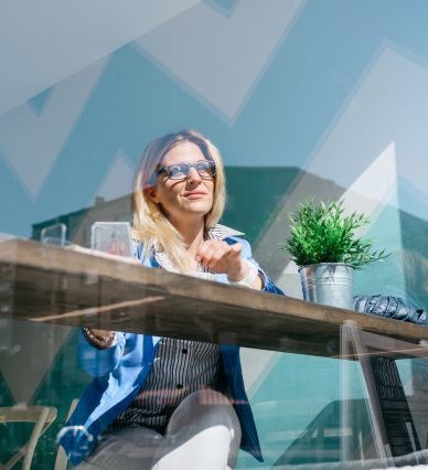 Young working girl stiring coffee in a cafe